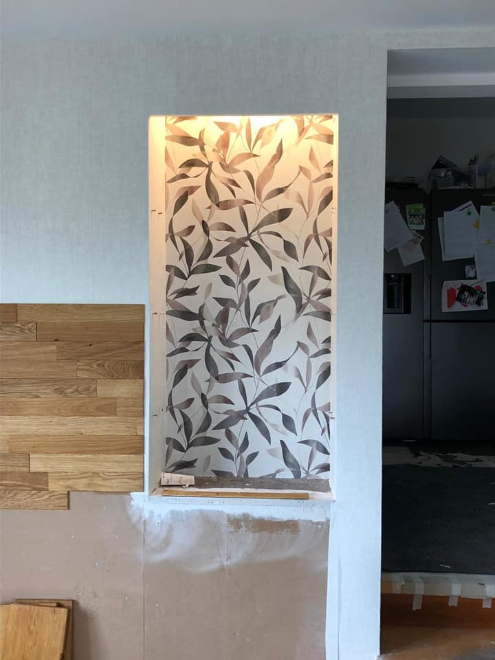 Tapete mit Blattmuster als Wandstreifen zwischen der Holzverkleidung.