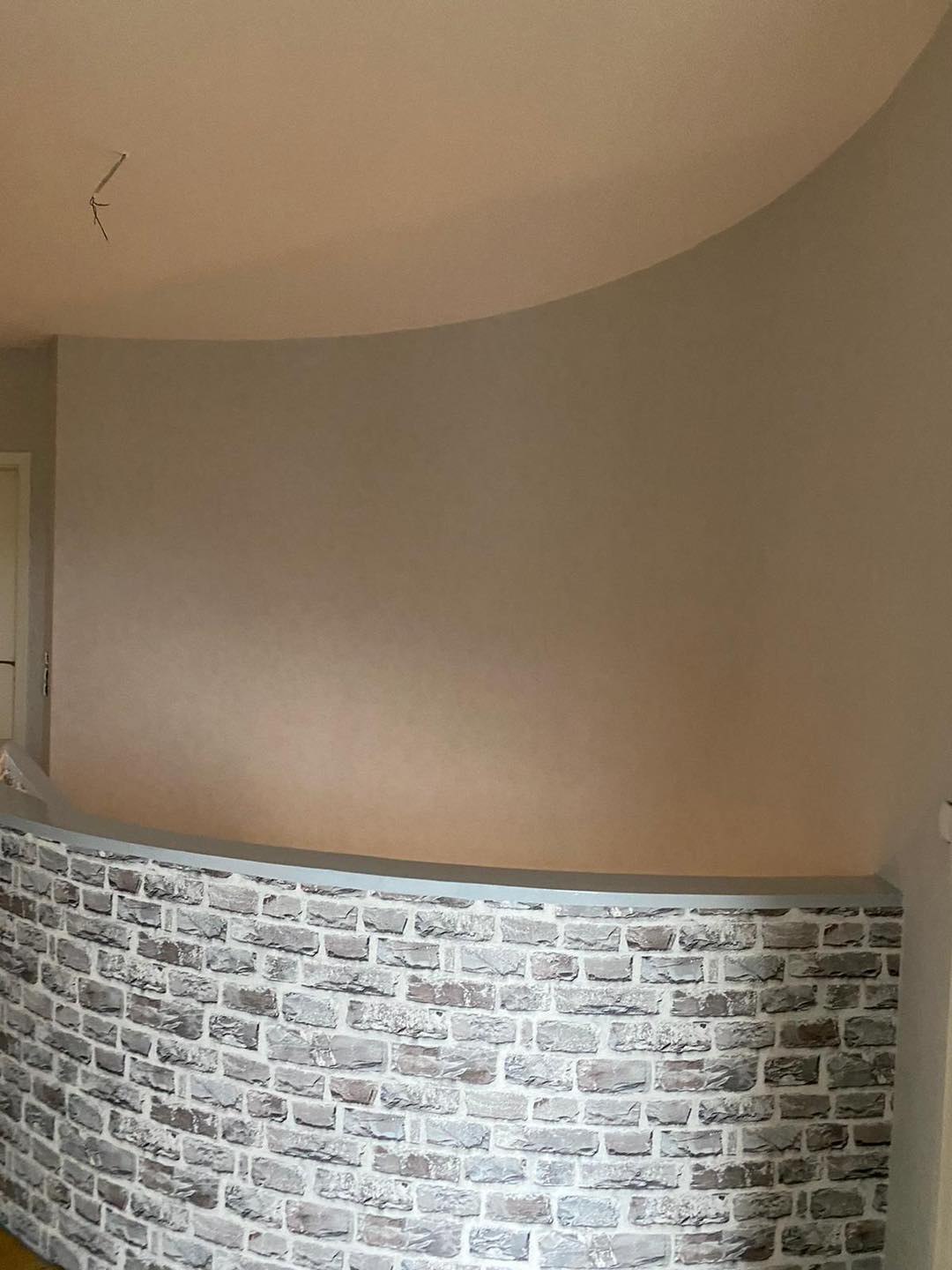 Obere Galerie mit der Brüstung in Steinoptik unter heller Wand und Decke.